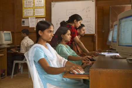 Téléchargez les photos : Enseignant transmettant des connaissances informatiques aux jeunes ruraux dans une initiative socio-économique de classe lancée par l'ONG Chinmaya Organization of Rural Development CORD, Sidhbari, Himachal Pradesh, Inde - en image libre de droit
