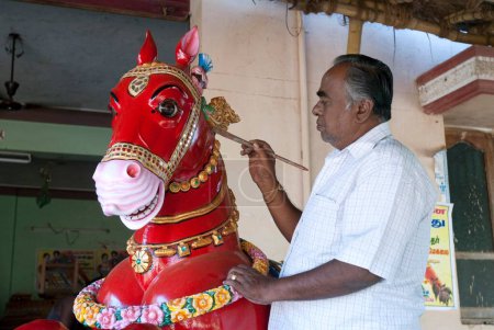 Photo for Man painting wooden horse vahanam at Karaikudi, Tamil Nadu, India - Royalty Free Image