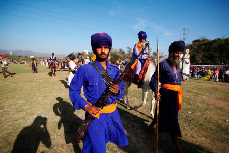 Foto de Nihang o guerrero sij llevando rifle durante la celebración de Hola Mohalla en Anandpur sahib en el distrito de Rupnagar Punjab, India - Imagen libre de derechos