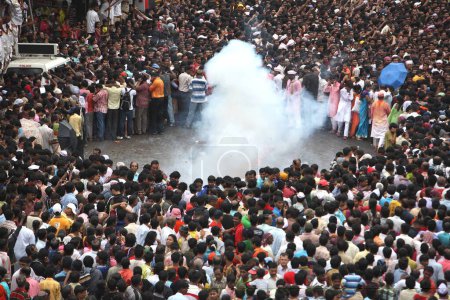 Téléchargez les photos : Crackers smog formes tandis que les dévots regarder ganesh immersion à Bombay Mumbai, Maharashtra - en image libre de droit