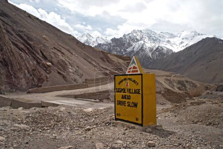Téléchargez les photos : Saspol village and drive slow signboard at leh kargil road and Himalayan mountain ; Ladakh ; Jammu and Kashmir ; India 9-April-2008 - en image libre de droit