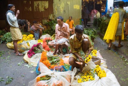 Téléchargez les photos : Vendeur de fleurs Tri Fleurs à Marché aux fleurs ; Howrah ; Kolkata ; Bengale Occidental ; Inde - en image libre de droit