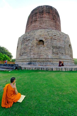 Foto de Monje rezando en Dhamekh stupa (siglo V d.C.); sitio budista en Sarnath cerca de Varanasi; Uttar Pradesh; India - Imagen libre de derechos