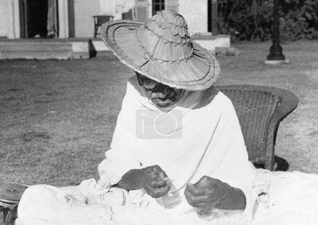 Foto de Mahatma Gandhi vistiendo un sombrero Noakhali mientras giraba en Birla House, Nueva Delhi, India, noviembre 1947 - Imagen libre de derechos