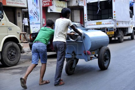 Photo for Boys Carrying Water Tank at Mumbai Maharashtra India - Royalty Free Image