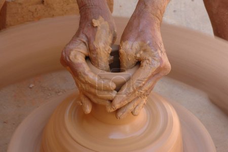 Pottery ; The traditional Indian kumbhar ( potter ) Earthen Clay pot maker; Making Clay pot on the Wheel; Rural workmanship of earnings; Malewad; Shiroda ; Sindhudurga ; Maharashtra ; India
