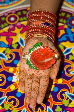 Photo for Woman holding diya dip dipak oil lamp , Mehandi heena pattern with rangoli mat , Diwali deepawali festival , India - Royalty Free Image