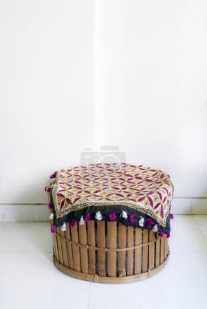 A cane stool with a embroidered cloth on a it in the living room of a house ; Mulund ; Bombay Mumbai ; Maharashtra ; India