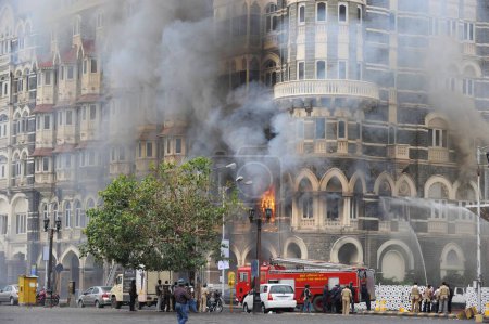 Téléchargez les photos : Incendie à l'intérieur de l'hôtel Taj Mahal et des pompiers prenant position à l'extérieur de l'hôtel ; après l'attaque terroriste de Deccan Moudjahidine le 26 novembre 2008 à Bombay Mumbai ; Maharashtra ; Inde - en image libre de droit