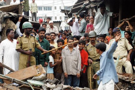 Téléchargez les photos : Les policiers veillent à prévenir tout incident fâcheux lors de la démolition de bidonvilles illégaux sur la route Mankhurd Link à Bombay maintenant Mumbai, Maharashtra, Inde - en image libre de droit