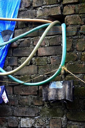 Téléchargez les photos : Tuyau d'eau illégal dans un mur de briques ; Nirankar Nagar ; Malvani ; Malad ; Bombay Mumbai ; Maharashtra ; Inde 25-août-2009 - en image libre de droit