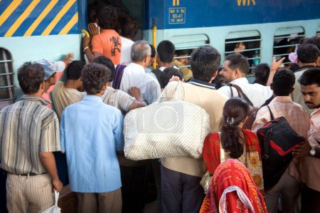 Téléchargez les photos : Les navetteurs essayant d'embarquer dans le train postal à la gare de Borivali, Bombay Mumbai, Maharashtra, Inde - en image libre de droit