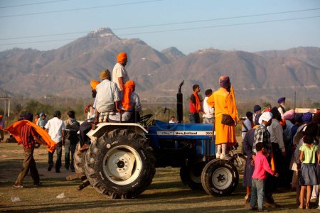 Photo for People watching stunts during the Hola Mohalla celebration at Anandpur sahib in Rupnagar district, Punjab, India - Royalty Free Image