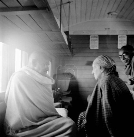 Téléchargez les photos : Mahatma Gandhi parlant avec Agatha Harrison dans un compartiment de train, 1946, Pyarelal Nayar - en image libre de droit