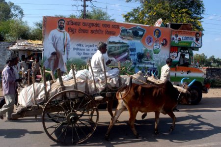 Téléchargez les photos : Un chariot à boeufs passant par le véhicule de campagne du candidat du Congrès de la circonscription de Chimur du district de Chandrapur de Nagpur du Maharashtra ; Inde - en image libre de droit