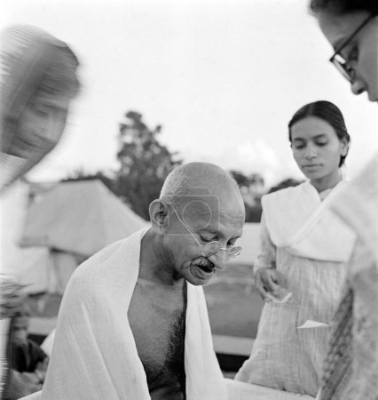 Photo for Mahatma Gandhi giving an autograph on his 75th birthday at Pune, Maharashtra, India, October 2, 1944 - Royalty Free Image