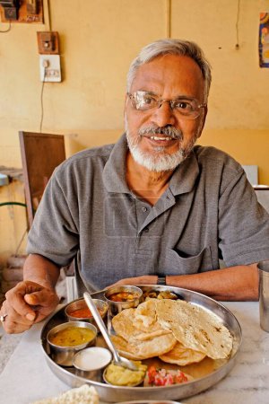 Foto de Hombre comiendo tali vegetariano maharashtriano, taluka Junnar, distrito Pune, Maharashtra, India - Imagen libre de derechos