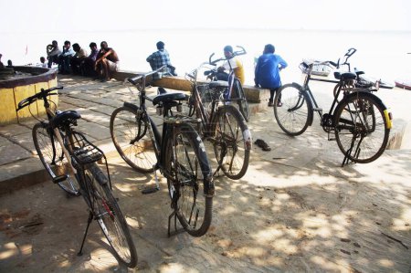 Téléchargez les photos : Quatre vélos garés ; Rivière Gange Ganges ; Assi Ghat ; Varanasi ; Uttar Pradesh ; Inde - en image libre de droit
