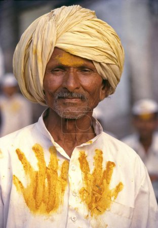 Foto de Devoto Khandobas con la cara untada con polvo de cúrcuma y ropa incrustada con impresiones de palma como prueba de la visita al festival, Jejuri, Maharashtra, India - Imagen libre de derechos