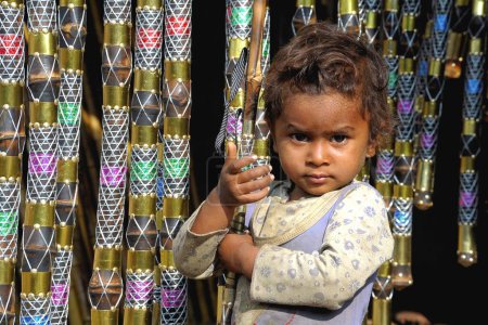 Foto de Niño sosteniendo bambúes en las manos, feria Pushkar, Rajastán, India - Imagen libre de derechos