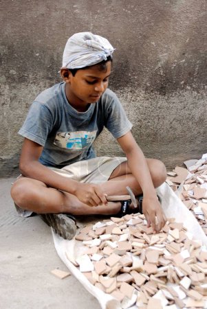 Photo for Child labourer breaking tiles, Bombay Mumbai, Maharashtra, India - Royalty Free Image