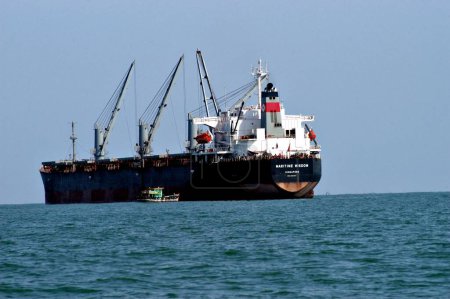 Téléchargez les photos : Transport maritime, Des tonnes de pétrole déversé à partir de Singapour vraquier basé Maritime Wisdom quand une péniche s'est précipité dans elle au large de Dona Paula Jetty, Goa, Inde - en image libre de droit