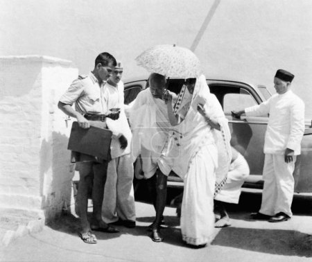 Foto de Mahatma Gandhi y Rajkumari Amrit Kaur dejando un coche en la colonia de barrenderos Bhangi, Nueva Delhi, 1946, India - Imagen libre de derechos