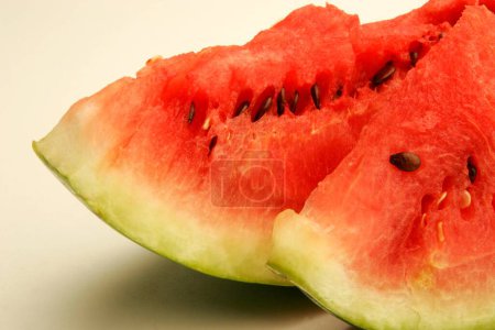 Fruits ; Two cut slices of watermelons showing red watery pulp and black seeds ; Pune; Maharashtra ; India