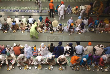 Foto de 300º año de consagración del Guru Granth Sahib el 30 de octubre de 2008, devotos Sikh comiendo en un Langar (cocina comunitaria tradicional) en Sachkhand Saheb Gurudwara, Nanded, Maharashtra, India - Imagen libre de derechos
