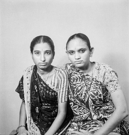 Photo for Old vintage 1900s black and white studio picture of twin sisters wearing saree India - Royalty Free Image
