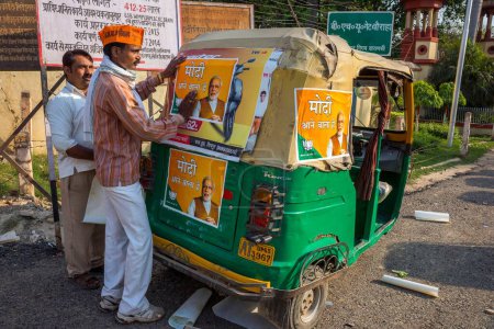 Photo for Man sticking poster on Auto rickshaw Varanasi uttar pradesh india Asia - Royalty Free Image