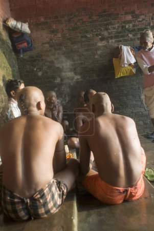 Photo for Praying for the dead Shradha (last ritual) ; Tonsuring head at Howrah Ghat ; Kolkata ; West Bengal  ; India - Royalty Free Image