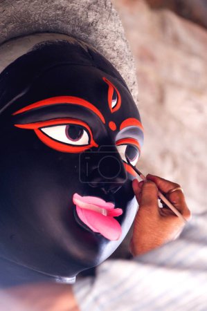 Photo for Artist painting eyes of goddess kali ; Kumartuli ; Calcutta Kolkata ; West Bengal ; India 14-October-2009 - Royalty Free Image