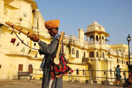 Téléchargez les photos : Musicien folklorique devant la porte du lac Pichola, Udaipur, Rajasthan, Inde - en image libre de droit