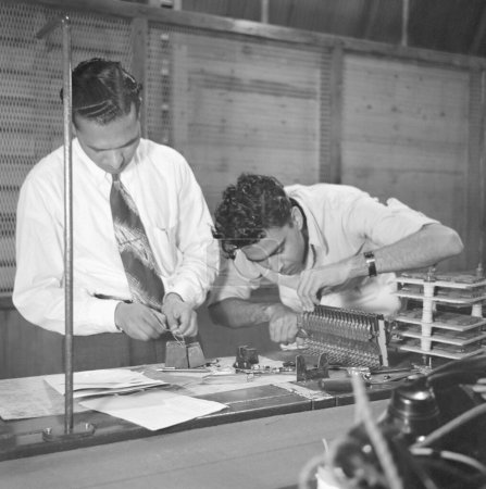 Foto de Hombres que trabajan en la fábrica de teléfonos, fabricación de instrumentos telefónicos en Bangalore, Karnataka, India, año 1950 - Imagen libre de derechos