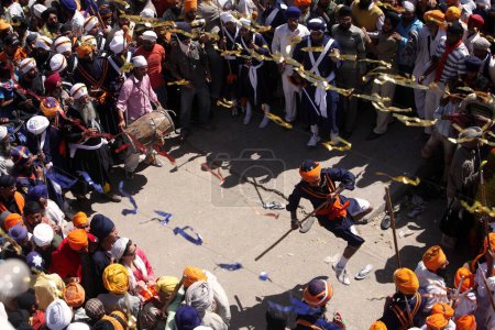 Foto de Guerreros nihang o sij realizando acrobacias con Bhala durante las celebraciones de Hola Mohalla en el sahib de Anandpur en el distrito de Rupnagar, Punjab, India - Imagen libre de derechos