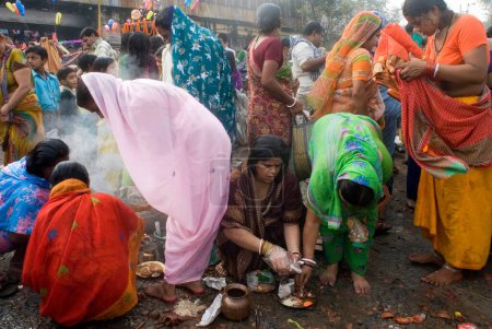Photo for Indian women praying at Babu Ghat on Kartik Purnima (Full Moon) celebration, Kolkata, West Bengal, India - Royalty Free Image