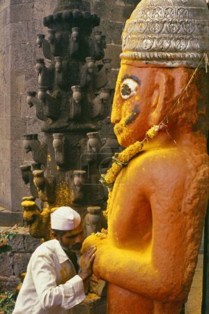 Foto de Estatua alta de color rojo anaranjado del demonio Malla que se había convertido de demonio a devoto de Khandoba, Jejuri, Maharashtra, India - Imagen libre de derechos