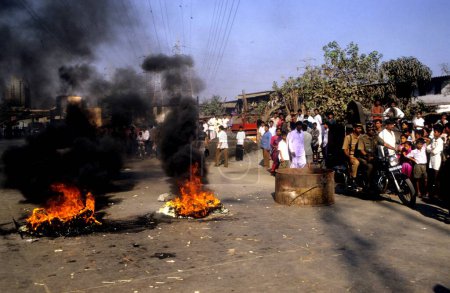 Téléchargez les photos : Des pneus sont brûlés au milieu de la route menant à un blocage des routes lors d'une dispute mineure entre deux groupes de personnes à Sewri, à Bombay maintenant Mumbai, Maharashtra, Inde - en image libre de droit
