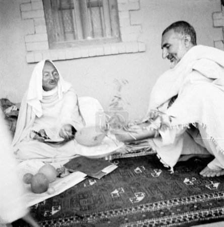Téléchargez les photos : Mahatma Gandhi s'entretenant avec Khan Abdul Gaffar Khan montrant un nid d'abeille dans son jardin lors de sa visite à Utmanzai Peshawar, dans les provinces frontalières du Nord-Ouest en Afghanistan, octobre 1938 - en image libre de droit