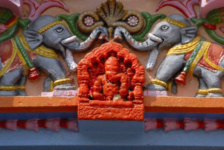 Ashtavinayak; Götzenbild von Lord Ganesh in scharlachroter Farbe mit zwei farbenfrohen Elefanten auf beiden Seiten an der Spitze des Eingangs des Shri Vighneshwar Vinayak Tempels; erbaut 1833 in Ozar; Taluka Junnar; District Pune; Maharashtra; Indien