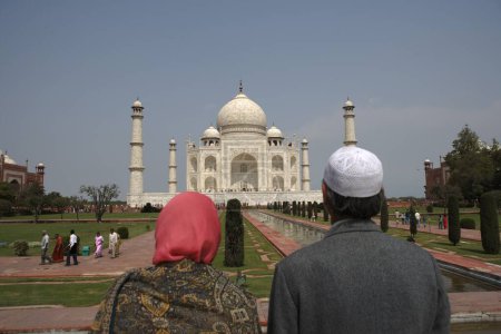 Téléchargez les photos : Couple Cachemire regardant au Taj Mahal Septième Merveilles du Monde sur la rive sud de la rivière Yamuna, Agra, Uttar Pradesh, Inde Site du patrimoine mondial de l'UNESCO - en image libre de droit