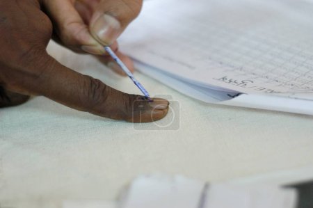 Photo for Inedible ink applied to fore finger during the 2004 Indian Loksabha elections at polling booth at Shivaji Nagar, Govandi, Mumbai Bombay, Maharashtra, India - Royalty Free Image