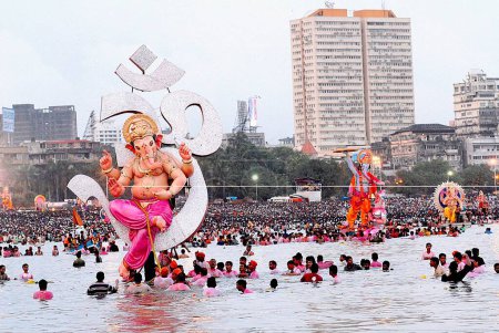 Photo for A huge Ganesh idol (elephant headed god) is immersed in to the sea at Girgaum Chowpatty, Bombay now Mumbai, Maharashtra, India - Royalty Free Image
