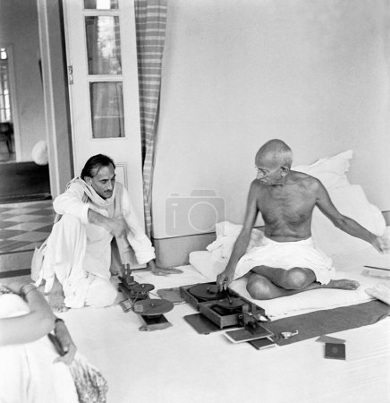 Photo for Mahatma Gandhi , spinning and talking with Acharya Kripalani at Birla House , Mumbai , 1945 NO MR - Royalty Free Image