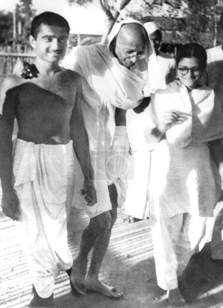 Foto de Mahatma Gandhi caminando con Abha y Kanu Gandhi (izquierda) - Imagen libre de derechos