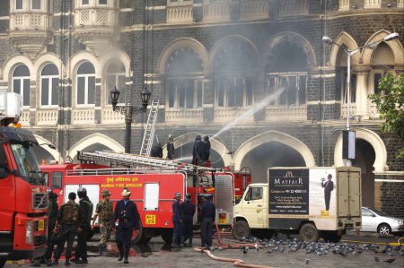 Téléchargez les photos : Des pompiers mettent le feu à l'hôtel Taj Mahal brûlé par des terroristes attaquent Bombay Mumbai ; Maharashtra ; Inde - en image libre de droit