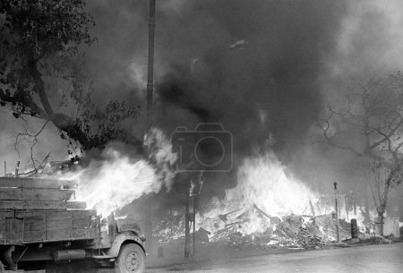 Photo for Rioters put on fire a timber mart shop in Reay Road after religious fundamentalists demolished the Babri Masjid in Ayodhya in Uttar Pradesh on 6 December 1992 ; The rioting continued till January 1993 in Bombay now Bombay Mumbai ; Maharashtra ; India - Royalty Free Image