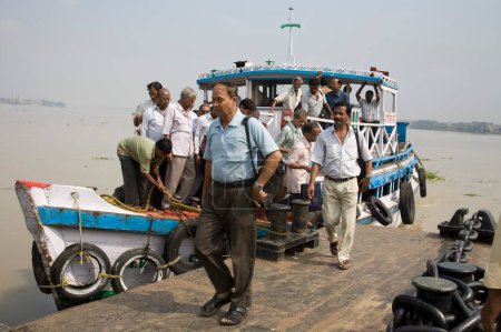 Téléchargez les photos : Activités à Hoostly river people getting down from boat at Belur Math, Calcutta now Kolkata, West Bengal, India - en image libre de droit