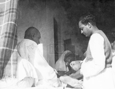 Foto de Mahatma Gandhi, Rajkumari Amrit Kaur y Ramakrishna Bajaj en Khadi Pratishthan, Sodepur, 24 Parganas, Calcuta, 1946, India - Imagen libre de derechos